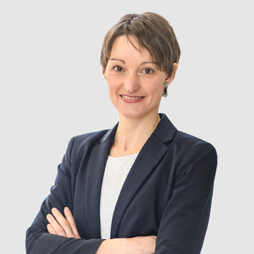 Prof. Bucher-Koenen hat kurze braune Haare und trägt einen dunkelblauen Anzug