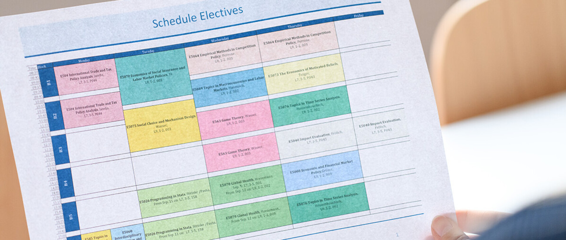 One person is holding a printout of a plan with elective courses.