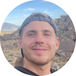 Portrait von Immanuel, einem Bachelorstudenten der Volkswirtschaftslehre. Er trägt eine Cap und hat einen Bart. Er steht vor einer Steinwüste.