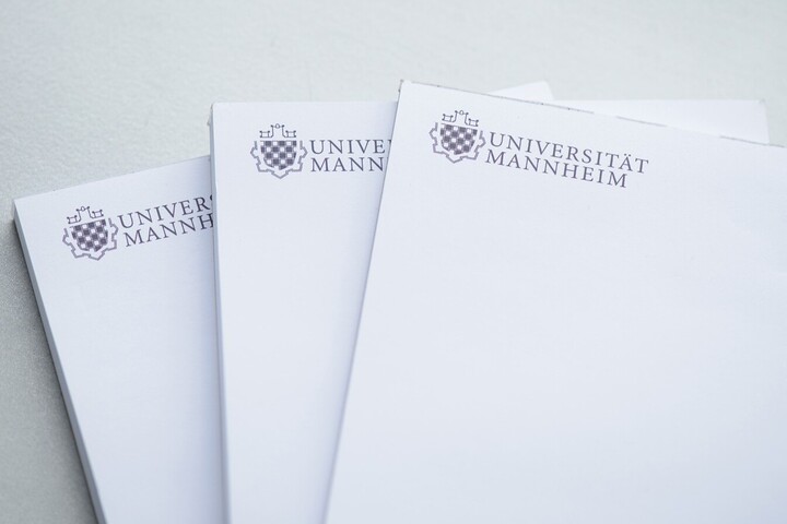 Drei mit dem Logo der Universität Mannheim versehene Notizblöcke