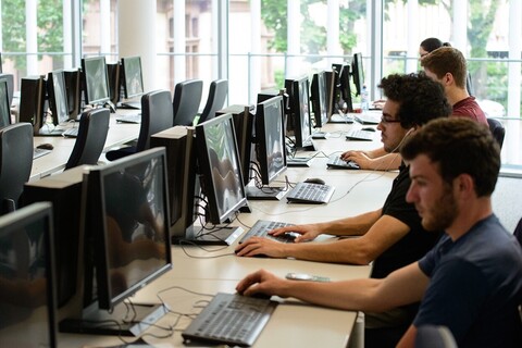 Blick in den VWL PC-Pool. Einige Studierende sitzen vor den Bildschirmen.