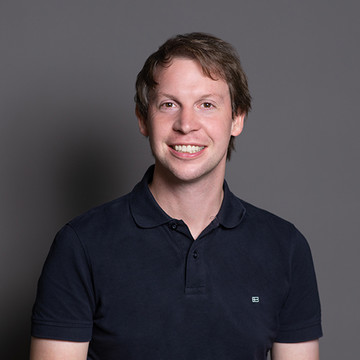 Portrait von Herrn Professor Hillenbrand. Er hat kurze braune Haare und trägt ein dunkelblaues Poloshirt. 
