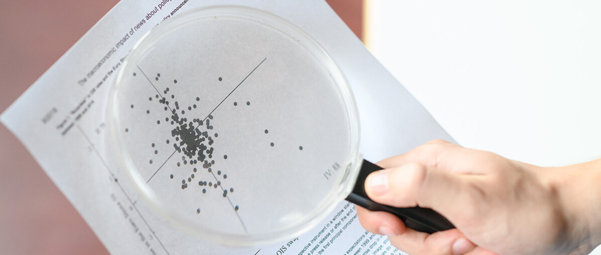 A scatter diagram is viewed with a magnifying glass.